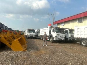 Presiden Director PT Mitra Teknindo Sejati, Alex Lin, berada di antara dump truck Howo. Foto: Dok. MTS